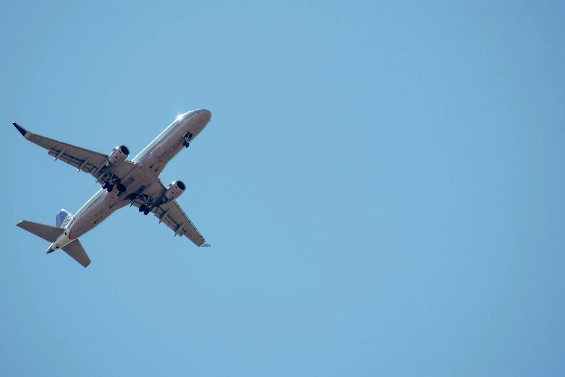 Un avión planeando en el claro cielo azul.